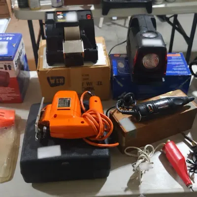Sale Photo Thumbnail #374: Assortment of power tools, hardware supplies, and household utility items, including a Makita finishing sander, an orange jigsaw, a rotary tool, and a Snake-It drain auger.
