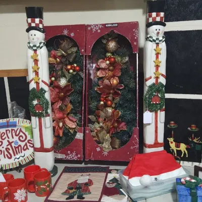Sale Photo Thumbnail #331: Collection of Christmas decorations including tall wooden snowman statues, boxed Kirkland floral swags, holiday mugs, and various festive tabletop decor.