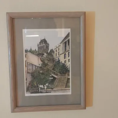 Sale Photo Thumbnail #37: Framed architectural art print depicting a European city scene with a horse-drawn carriage, presented in a light wood frame with gray matting.