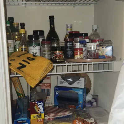 Sale Photo Thumbnail #245: Pantry shelf assortment including glass canning jars, spices, cooking oils, and household storage supplies.