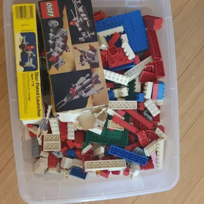 Sale Photo Thumbnail #20: Plastic storage tub filled with vintage loose LEGO building bricks and original Space theme set boxes from the late 1970s or early 1980s.