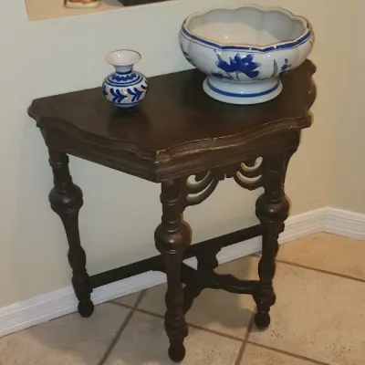 Sale Photo Thumbnail #129: Dark stained wooden corner console table with turned legs, paired with a blue and white ceramic bowl and a small matching vase.