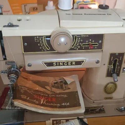 Sale Photo Thumbnail #195: Vintage Singer 401A Slant-O-Matic sewing machine in two-tone beige and cream, featuring original instruction manual and accessory tray.