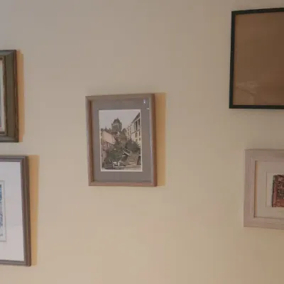 Sale Photo Thumbnail #30: A collection of framed artwork displayed on a wall, including landscape oil paintings, architectural prints, and watercolors in various frame styles.
