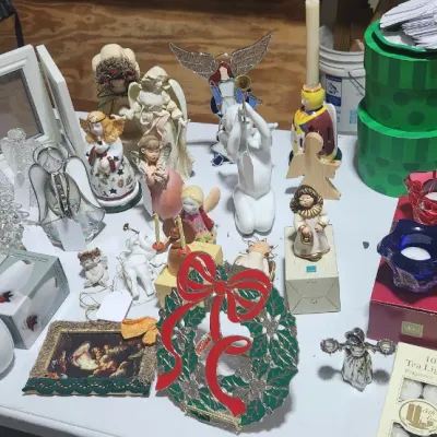 Sale Photo Thumbnail #326: An assortment of Christmas decorations and tabletop decor, featuring angel figurines, Santa Claus statues, votive candle holders, and picture frames.