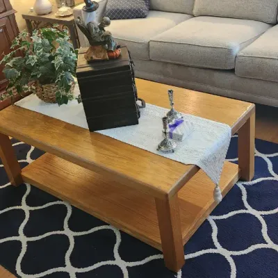 Sale Photo Thumbnail #165: Oak rectangular coffee table with lower shelf set on a navy blue and white trellis-pattern area rug.