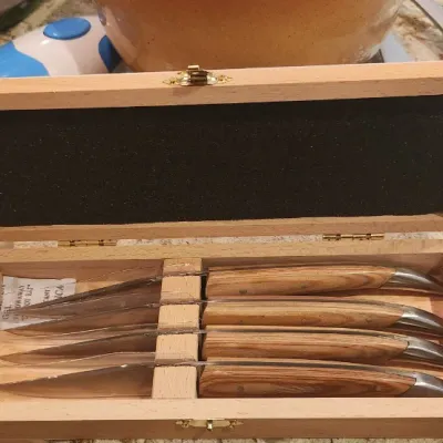 Sale Photo Thumbnail #234: Set of four Laguiole-style steak knives with natural wood handles, presented in an open wooden display box.