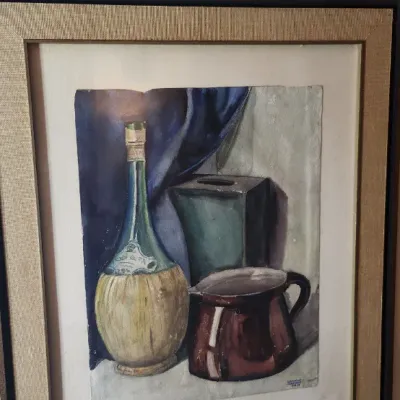 Sale Photo Thumbnail #207: Framed still life painting depicting a wicker-wrapped Chianti bottle, ceramic pitcher, and vessel against a draped blue backdrop. Housed in a textured mat with a dark wooden frame.
