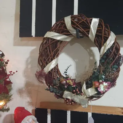 Sale Photo Thumbnail #335: Festive Christmas wreath made of woven branches wrapped with silver ribbon, alongside a small decorated artificial tabletop tree.