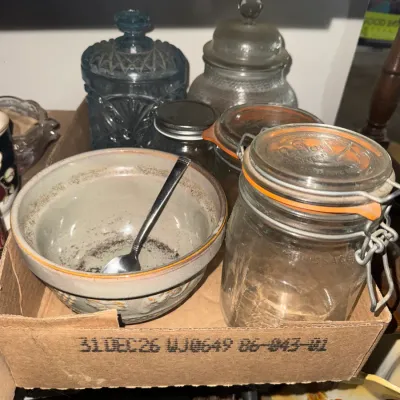 Sale Photo Thumbnail #5: Collection of vintage glassware and kitchen items, including a French Le Parfait wire-bale canning jar, a ceramic bowl with spoon, and decorative blue glass canisters.