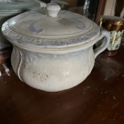 Sale Photo Thumbnail #38: Antique ceramic chamber pot with lid, featuring embossed detail and faint blue hand-painted accents.