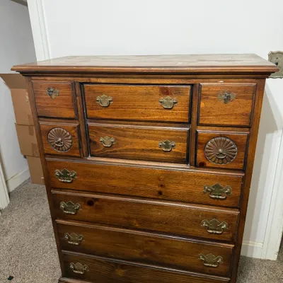 Sale Photo Thumbnail #30: Traditional wooden tallboy dresser with brass batwing hardware and decorative carved fan details on the upper drawers.