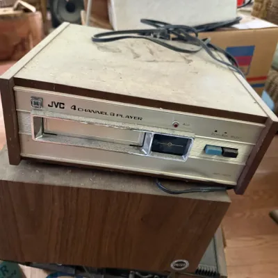 Sale Photo Thumbnail #33: Vintage JVC 4 Channel 8-track player with a woodgrain casing, showing surface dust and light wear.