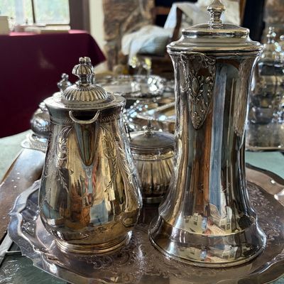 Sale Photo Thumbnail #31: Collection of silver serving pieces dating early 1900s. Shown is a teapot and chocolate server