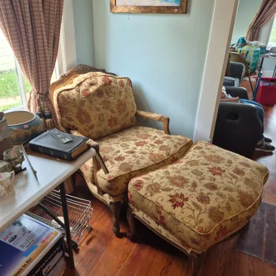 Sale Photo Thumbnail #37: French Provincial style armchair and matching ottoman featuring floral tapestry upholstery and carved wooden frames.