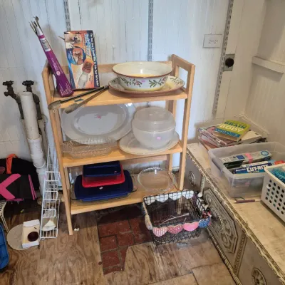 Sale Photo Thumbnail #27: Light wood three-tier shelving unit display holding kitchenware items, including ceramic bowls, serving platters, and glass baking dishes.