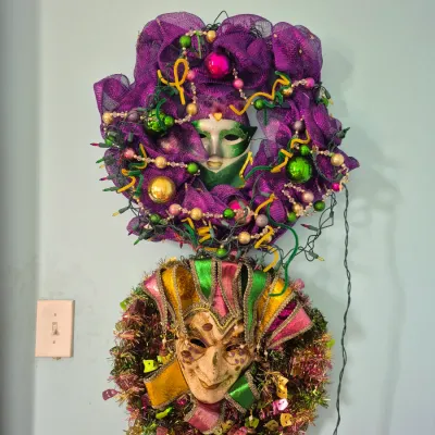 Sale Photo Thumbnail #85: Pair of Mardi Gras themed wreaths featuring masquerade masks, tinsel, purple mesh mesh ribbon, and string lights.
