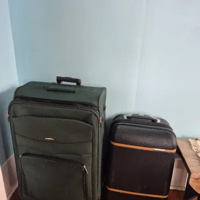 Sale Photo Thumbnail #66: Two softshell rolling suitcases, including a large dark green fabric model and a smaller black bag with tan trim.