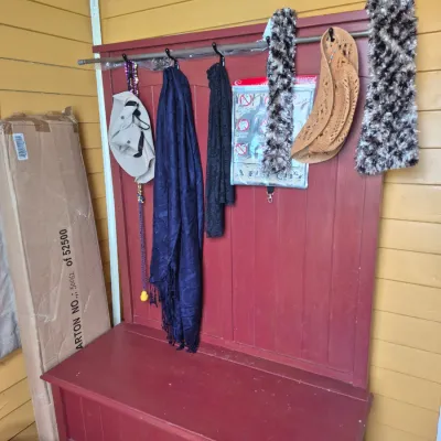 Sale Photo Thumbnail #103: Red painted wooden hall tree bench with built-in storage compartment and hanging hooks, displayed with various scarves and hats.