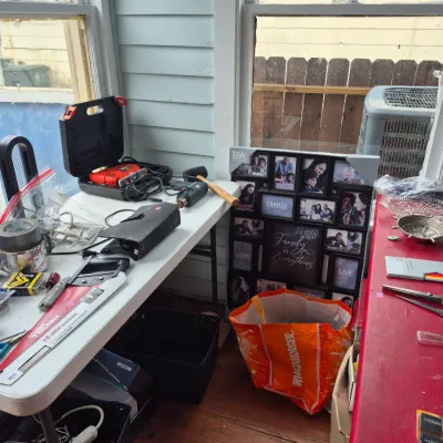 Sale Photo Thumbnail #30: Folding table displaying assorted hand tools and power tools, alongside a multi-picture collage frame resting on the floor.