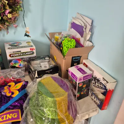 Sale Photo Thumbnail #84: Collection of Mardi Gras and holiday party supplies, including a glittery top hat, light projectors, and decorative items.