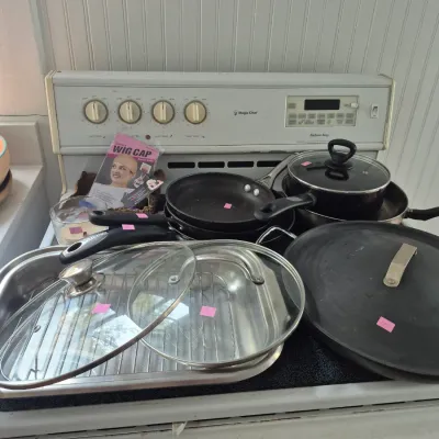 Sale Photo Thumbnail #20: Assortment of cookware including non-stick frying pans, pots, and a stainless steel roasting pan with a rack.