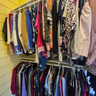 Sale Photo Thumbnail #89: Closet filled with two rows of women's clothing hanging on racks, featuring a variety of tops, jackets, patterns, and colors.