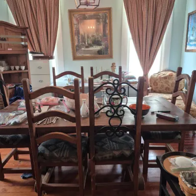 Sale Photo Thumbnail #62: Rustic wooden dining table and matching chairs set, featuring pattern-upholstered seats, wrought iron detail, and various table displays.