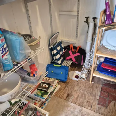 Sale Photo Thumbnail #24: Assorted household goods, tote bags, cookbooks, and kitchen items organized on wire and wooden shelving units.