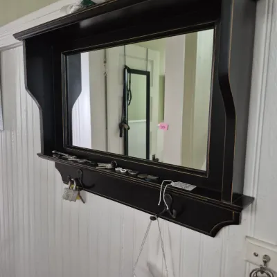 Sale Photo Thumbnail #57: Black painted wall-mounted coat rack featuring an upper shelf, center rectangular mirror, lower display ledge, and metal hanging hooks.
