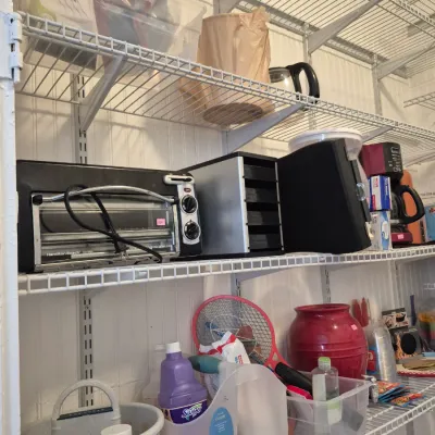 Sale Photo Thumbnail #22: Wire shelving unit filled with household items including a Hamilton Beach toaster oven, coffee maker, cleaning supplies, and storage containers.