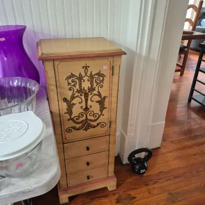 Sale Photo Thumbnail #14: Hand-painted freestanding jewelry armoire with intricate scrollwork design on the top door and three lower drawers.