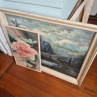 Sale Photo Thumbnail #32: Two framed vintage artworks, including a small floral painting of a pink peony and a large landscape painting depicting a house near water under a stormy sky.
