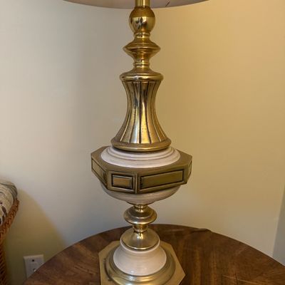 Vintage brass and ceramic table lamp with an ornate geometric base, topped with a pleated fabric shade.