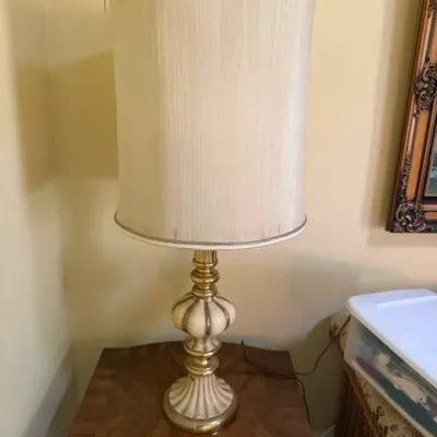 Vintage brass and ceramic table lamp with a tall cylindrical textured fabric shade.