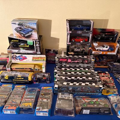 Large collection of boxed and carded die-cast toy cars and NASCAR haulers, including Hot Wheels, Racing Champions, and MPC model kits.