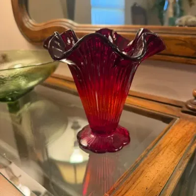 Vintage ruby red glass vase featuring a ribbed body with a ruffled rim and scalloped base.