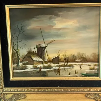 Framed oil painting depicting a winter landscape with figures ice skating near a Dutch windmill, housed in an ornate ornate gold-finished...