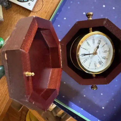 Sale Photo Thumbnail #125: Vintage Bulova gimbaled nautical desk clock housed in an octagonal wooden case.