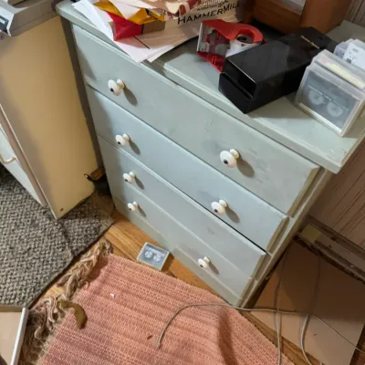 Sale Photo Thumbnail #68: Four-drawer light green painted wooden chest topped with office supplies, paper stacks, and media storage.