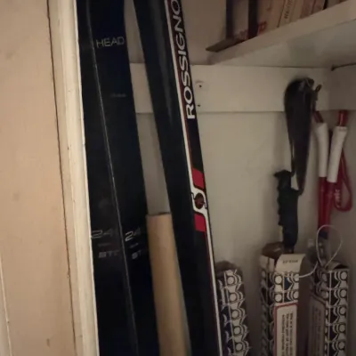 Sale Photo Thumbnail #84: Vintage Head and Rossignol snow skis with ski poles, stored inside a closet.