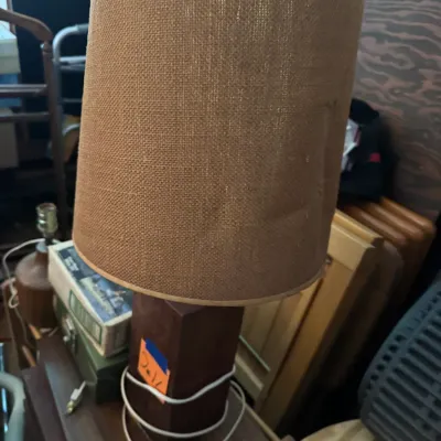 Sale Photo Thumbnail #163: Vintage table lamp featuring a solid dark wood block base and a textured burlap drum shade, styled in a mid-century modern aesthetic.