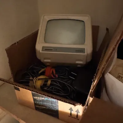 Sale Photo Thumbnail #168: Vintage Uniden small CRT monitor or mini television set stored in a cardboard box alongside bundled cables.