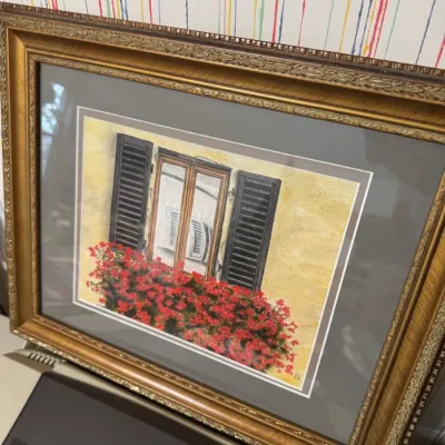 Sale Photo Thumbnail #46: Framed artwork depicting a window with open black shutters and red flowers, housed in an ornate gold-finished frame with grey matting.