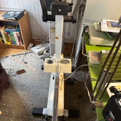 Sale Photo Thumbnail #52: Vintage white and black stationary exercise bike with built-in dials, featuring minor surface wear and discoloration.