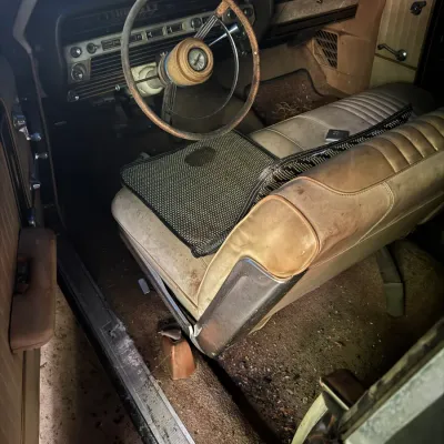 Sale Photo Thumbnail #27: Interior view of a vintage 1960s automobile showing a bench seat, dashboard, and steering wheel in weathered, project-car condition.