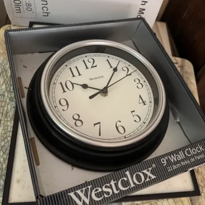 Sale Photo Thumbnail #153: Westclox 9-inch round wall clock with a silver-tone bezel and black frame, presented in its original retail box.