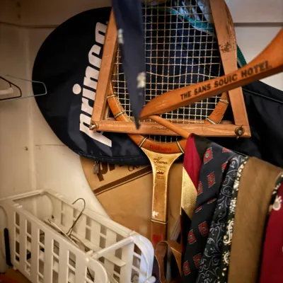 Sale Photo Thumbnail #76: Vintage Wilson Jack Kramer wooden tennis racket in a wooden press frame, stored in a closet alongside neckties, coat hangers, and a modern Prince racket bag.