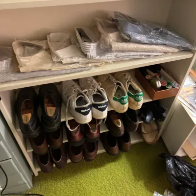 Sale Photo Thumbnail #36: White wooden bookcase filled with men's dress shirts in original plastic packaging, dress shoes, and vintage sneakers including Adidas Stan Smiths.