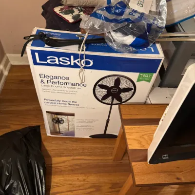Sale Photo Thumbnail #93: Lasko Elegance & Performance pedestal fan in original retail box, stored alongside various linens, bedding, and home goods.